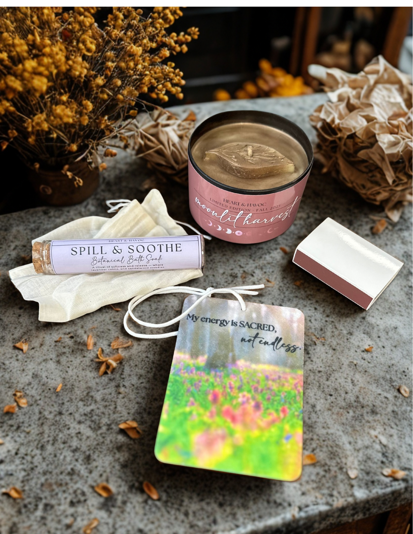 Candle, bath salt, and diffuser on a stone surface with decorative elements.