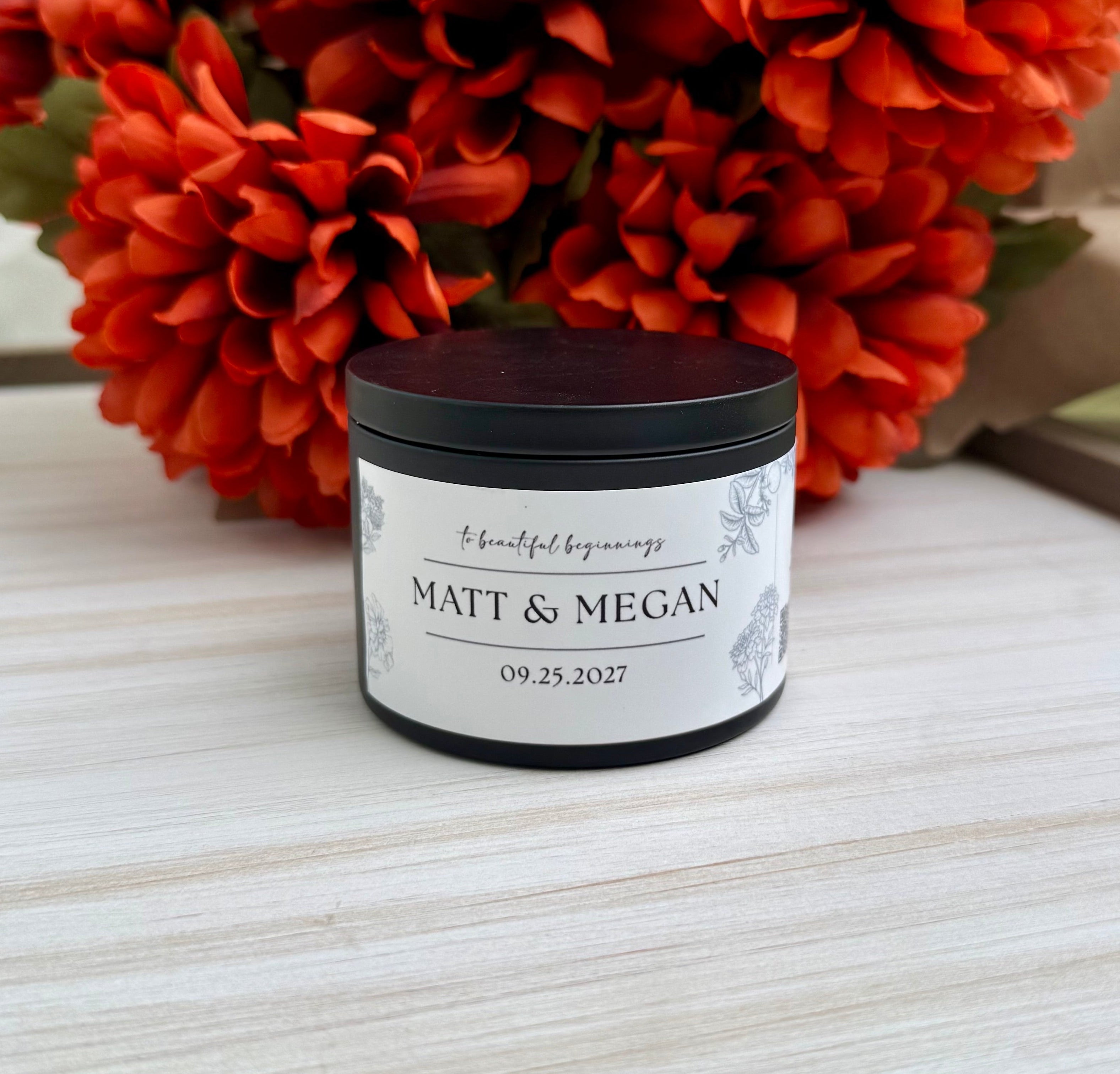 A small black jar candle with a white personalized label reading 'MATT & MEGAN' and the date '09.25.