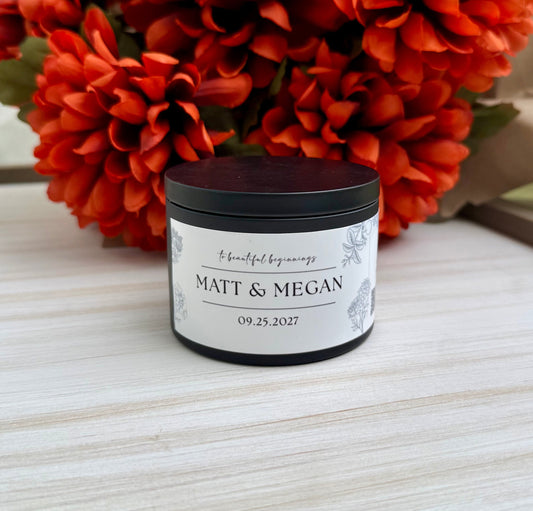A small black jar candle with a white personalized label reading 'MATT & MEGAN' and the date '09.25.