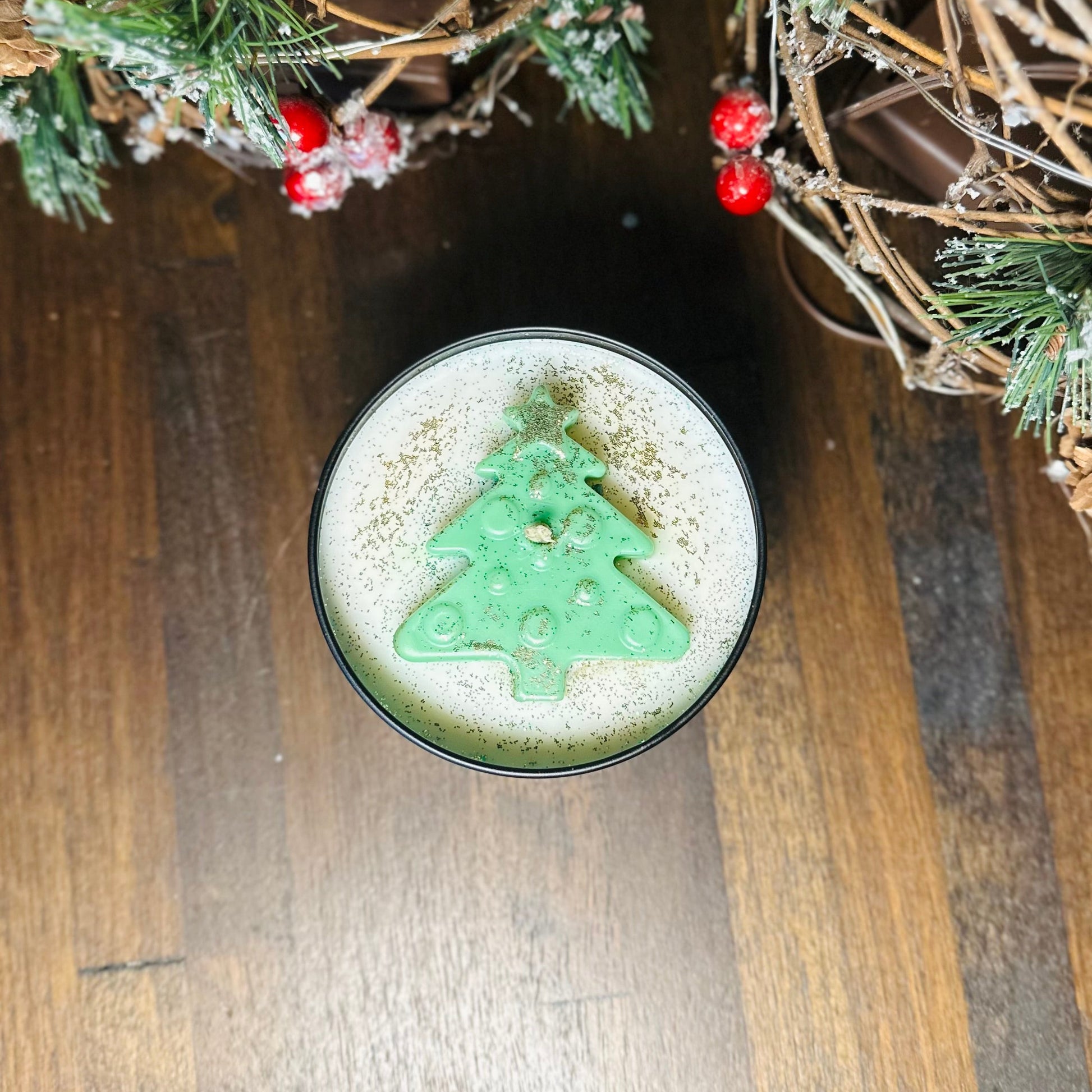 Green Christmas tree-shaped foam on a drink with festive decorations in the background